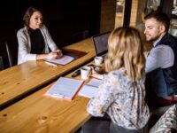 Im Rahmen eines Bewerbungsgesprächs werden Fragen an eine Bewerberin gestellt.