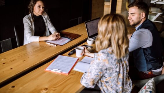 Im Rahmen eines Bewerbungsgesprächs werden Fragen an eine Bewerberin gestellt.