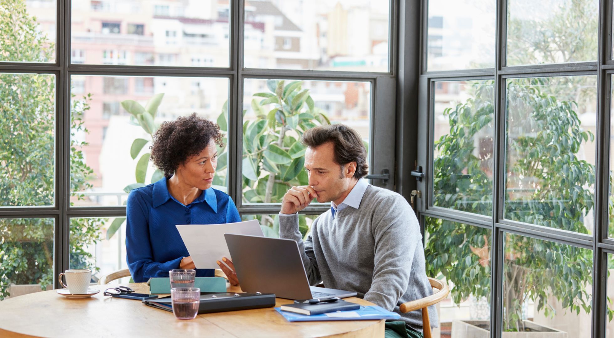 Eine Frau und ein Mann besprechen Dokumente während eines Meetings im Büro. 